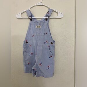 Little girl, Oshkosh blue with red cherry overalls